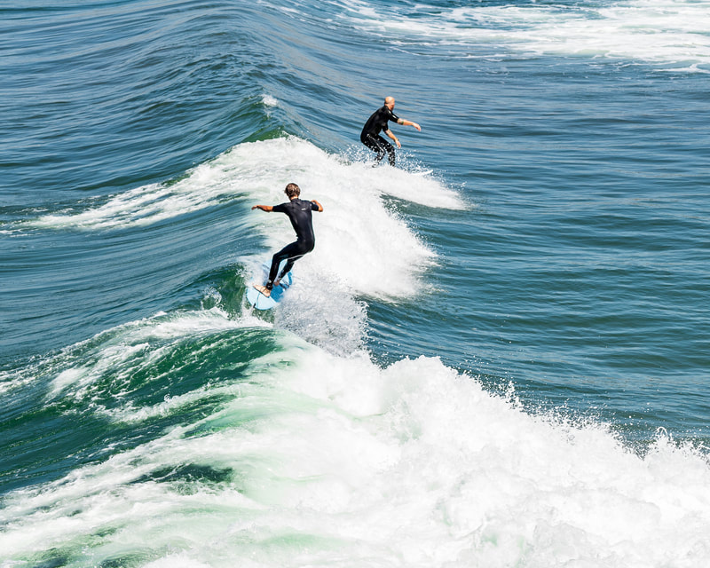 Surfers riding a small wave in.