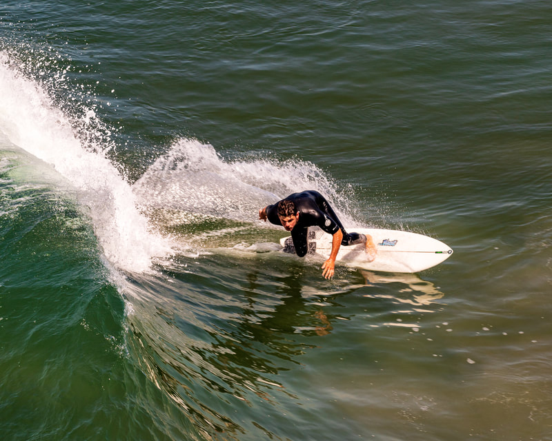 a surfer during the take-off with his reflection in the water. 
